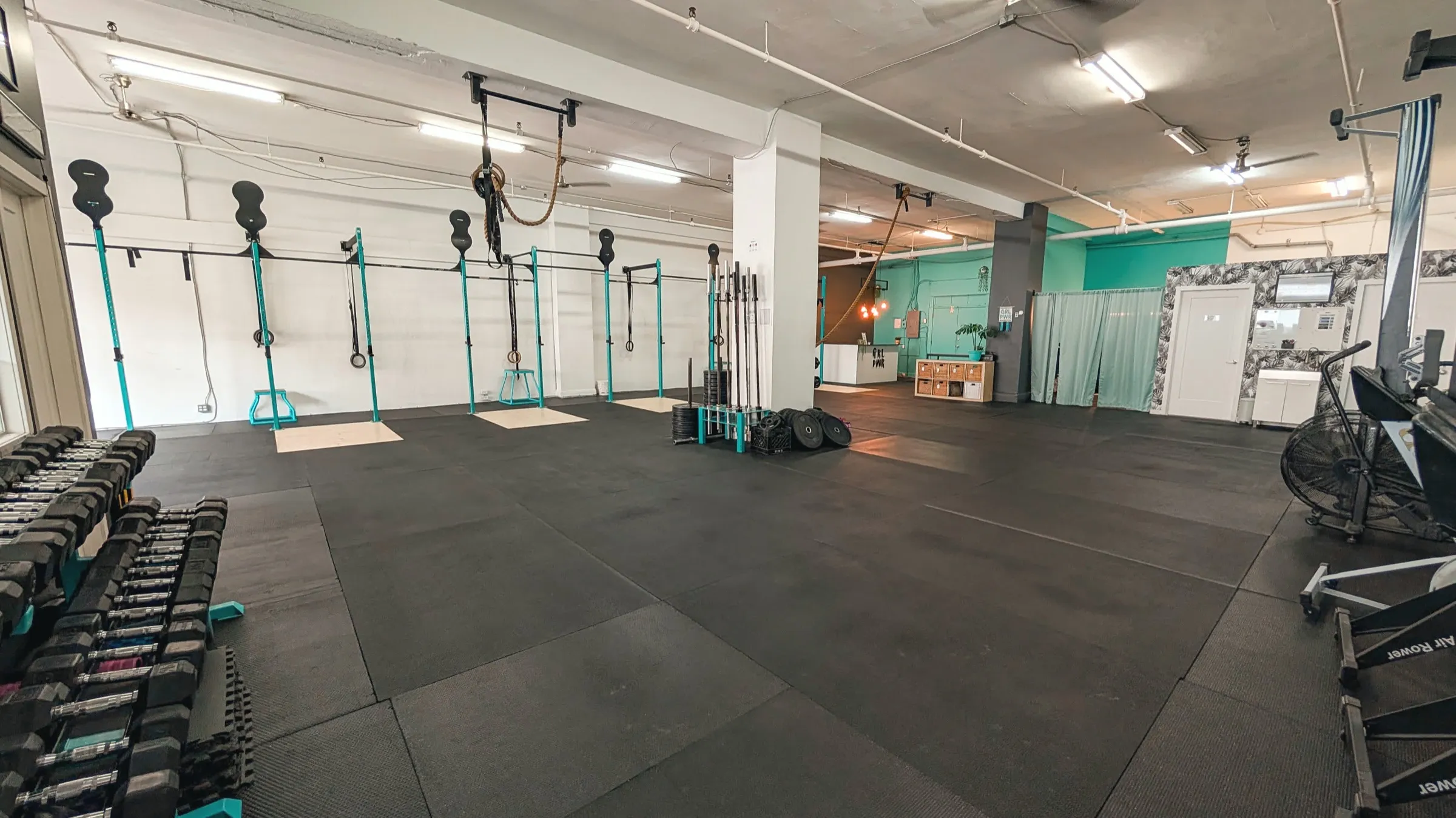 Plateau d'entraînement ouvert de ~2 000 pi² avec rig, haltères, disques et cardio
