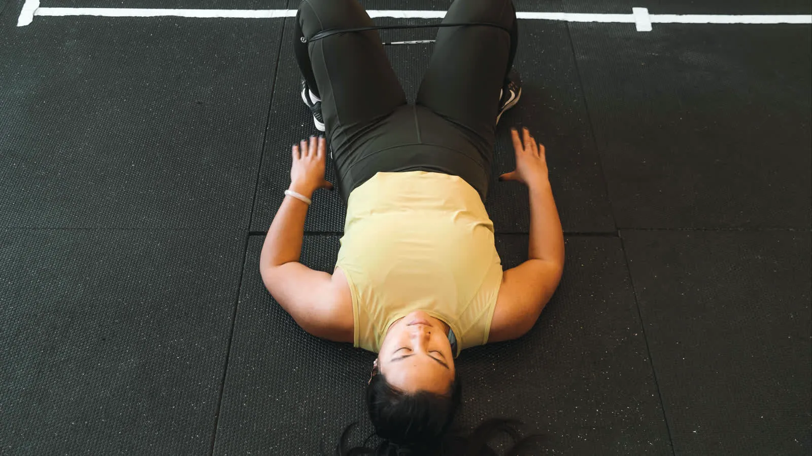 Femme au repos sur le sol, récupération au gym MissFit Montréal