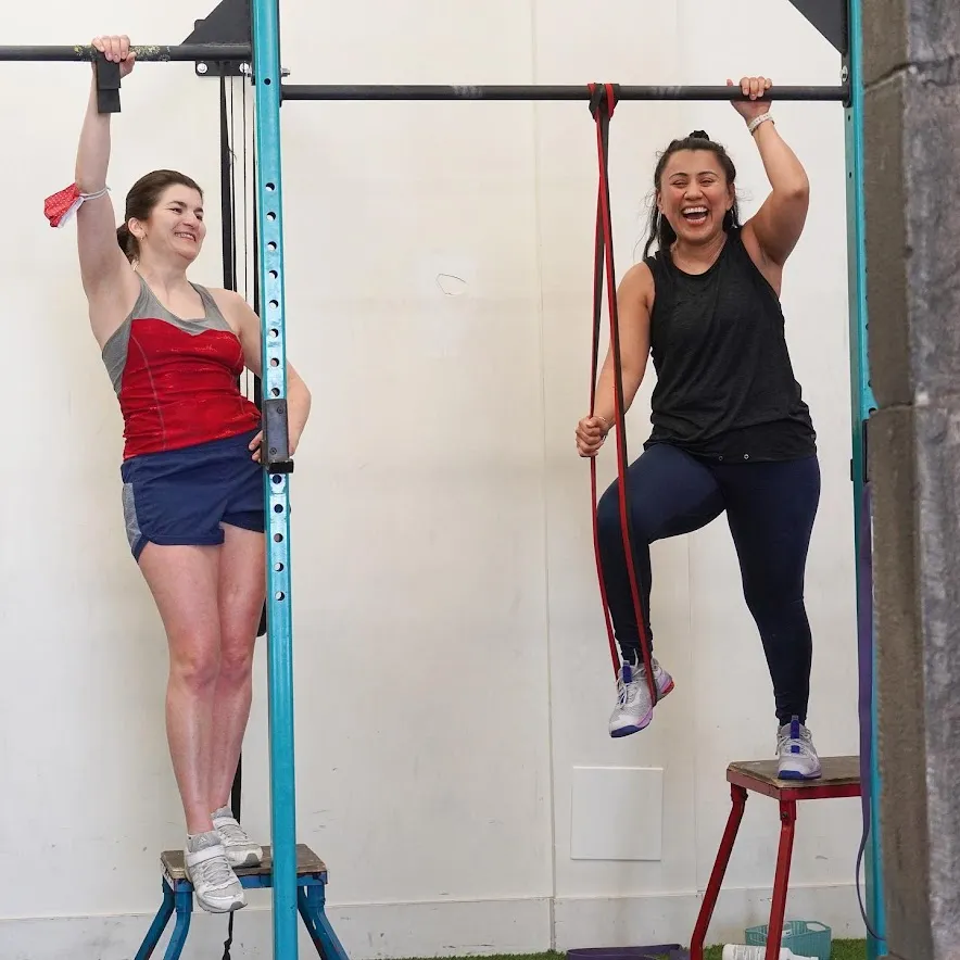 Femmes qui apprennent les tractions avec bandes élastiques chez MissFit Montréal